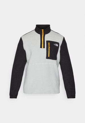 Fleece pullover in grey and black with high collar, half-zip front, zippered chest pocket, and contrasting yellow zipper detail.