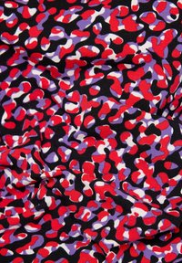 Stoff mit einem zerknitterten, bunten Leopardenmuster in Rot, Lila, Weiß und Schwarz.