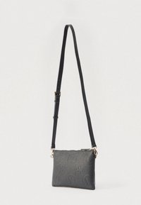 Musta teksturoidusta nahasta valmistettu olkakassi. Varustettu säädettävällä hihnalla, kultaisilla metalliosilla sekä kohokuvioiduilla kukka- ja logokuvioilla.