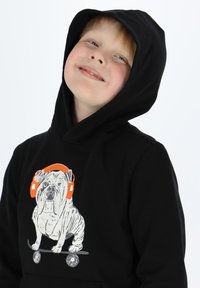 Black hoodie with a gray bulldog graphic wearing orange headphones, standing on a skateboard. Soft fabric with a relaxed fit.