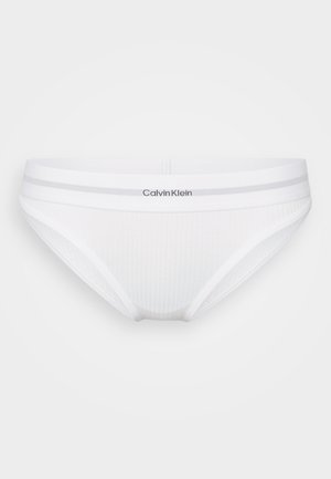 Bóxer blancos de Calvin Klein con textura acanalada, cintura elástica con dos rayas grises y logo de la marca en la parte frontal.