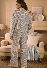 Floral-patterned pajama set in light blue and cream, featuring long sleeves, wide legs, and lace accents at the cuffs.