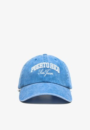 Modrá baseballová čiapka s bielym vyšitým textom "Puerto Rico San Juan" na prednej strane, zobrazená na bielom pozadí.