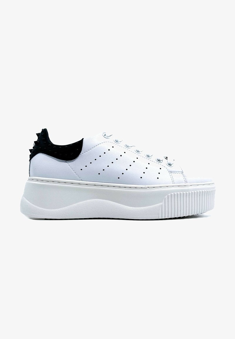 Sneaker bianco con una suola piatta testurizzata, dettagli in tacco a spillo neri, tomaia forata e cuciture decorative. Presenta una chiusura con lacci.