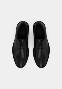 Μα ύρα δερμάτινα παπούτσια με λείο φινίρισμα, στρογγυλεμένη μύτη και κορδόνια, με ελάχιστες ραφές και λεπτή σόλα από καουτσούκ.