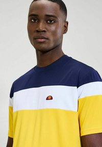 Camiseta de manga corta con rayas horizontales en azul marino, blanco y amarillo, con un logo bordado en el pecho. Fabricada en tela suave.