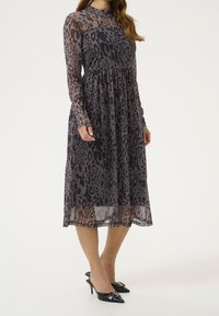Robe à imprimé léopard avec des manches longues, en tissu chiffon léger, taille froncée, ourlet asymétrique, design superposé en gris et noir.