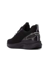 Zapato deportivo negro con parte superior de tejido texturizado, cuello acolchado y un acento en el talón negro brillante. Presenta detalles reflectantes en la parte trasera.