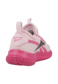 Zapatilla deportiva de malla rosa con una suela de goma texturizada, sutiles acentos grises y un destacado logo de Reebok en el talón y el costado.