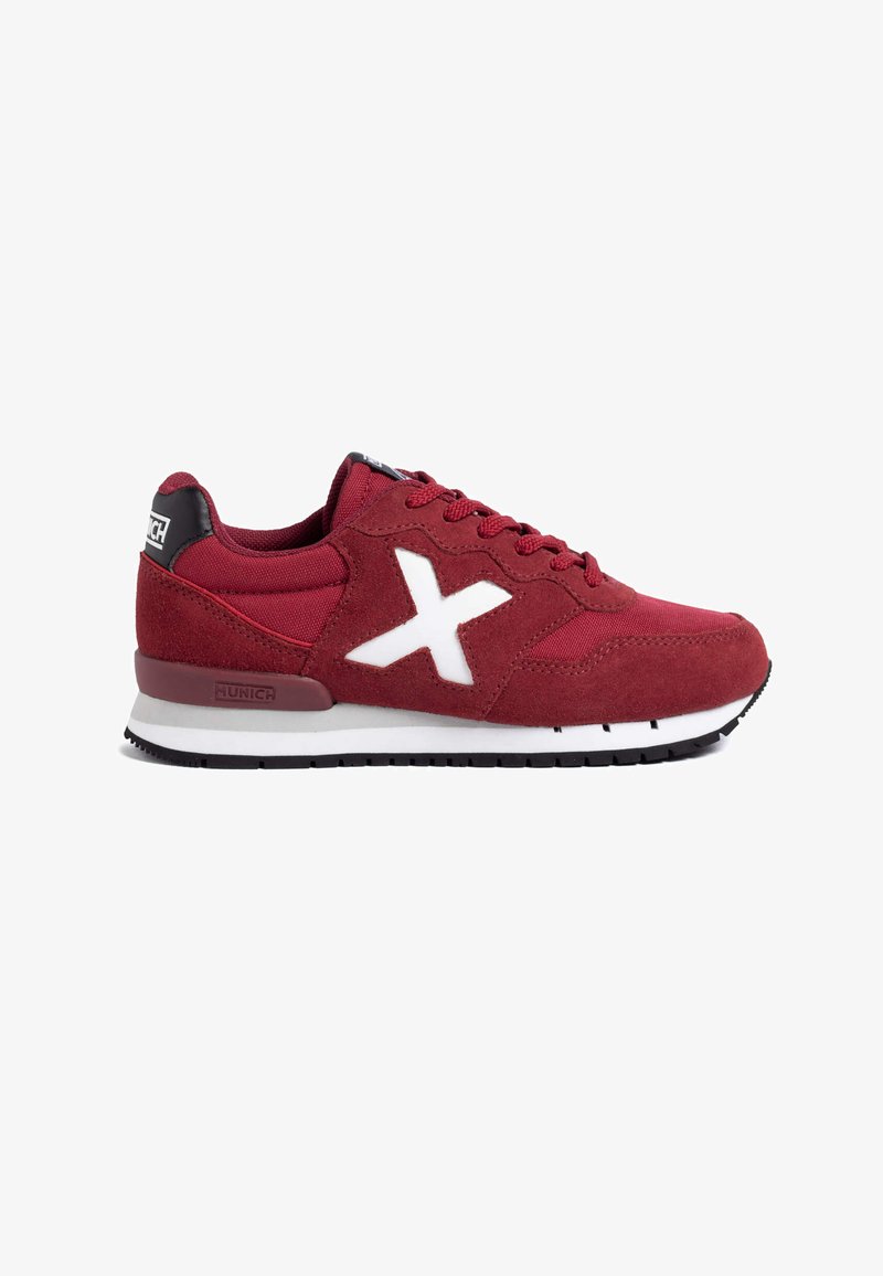 Zapatillas de ante rojo y malla con acentos blancos, que cuentan con un distintivo logo en forma de X, diseño de cordones y una pestaña en negro en una suela blanca y negra.