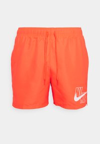 Fényes narancssárga úszónadrág rugalmas derékkal és zsinórral, a bal oldalon fehér Nike logóval. Rugalmas anyagból készült.