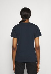 Camiseta de algodón azul marino con cuello redondo y mangas cortas, que presenta una textura suave y un diseño simple en la parte posterior.