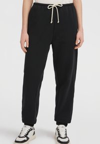 Sorte sweatpants med en afslappet pasform, lavet af blødt bomuld. De har en elastisk talje med snøre og ribbede manchetter.
