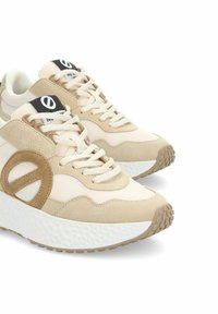 Baskets beiges avec une tige en maille, des accents en daim et une semelle intermédiaire texturée blanche. Présente un patch de logo rond et des lacets à l'avant.