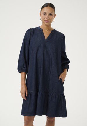 Tummansininen, denim-mekko, jossa on V-pääntie, puffihuput ja kerroksellinen, frillattu helma. Mukana sivutaskut ja rento istuvuus.