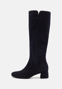 Botas de ante azul marino hasta la rodilla, con un tacón ancho, textura suave y un diseño elegante con una sutil abertura en la parte superior.