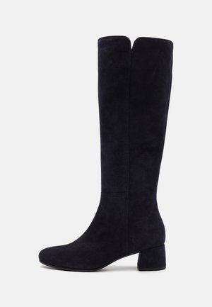 Knee-high navy suede boots, featuring a block heel, smooth texture, and a sleek design with a subtle split at the top.