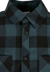 Flanellhemd mit einem schwarz-teal karierten Muster, knöpfbarem Frontverschluss, spitzem Kragen und einer Brusttasche. Weiche Stoffstruktur.