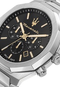 Orologio Maserati con cassa ottagonale in acciaio inox, quadrante nero, dettagli dorati, lancette luminose e subquadranti cronografici. Impermeabile fino a 100 metri.