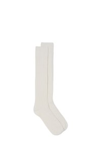 Calcetines crema hasta la rodilla con una textura acanalada, hechos de material suave. Presentan una parte superior lisa sin herrajes o patrones visibles.
