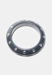 Kovinski obroč temno sive barve z gladko teksturo, z enakomerno razporejenimi srebrnimi zakovicami vzdolž zunanjega roba. Prazen sredinski del.