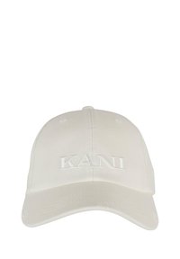 Vit baseballkeps i bomull med en böjd skärm och broderad "KANI" framtill. Innehåller ventilationshål ovanför kronan.