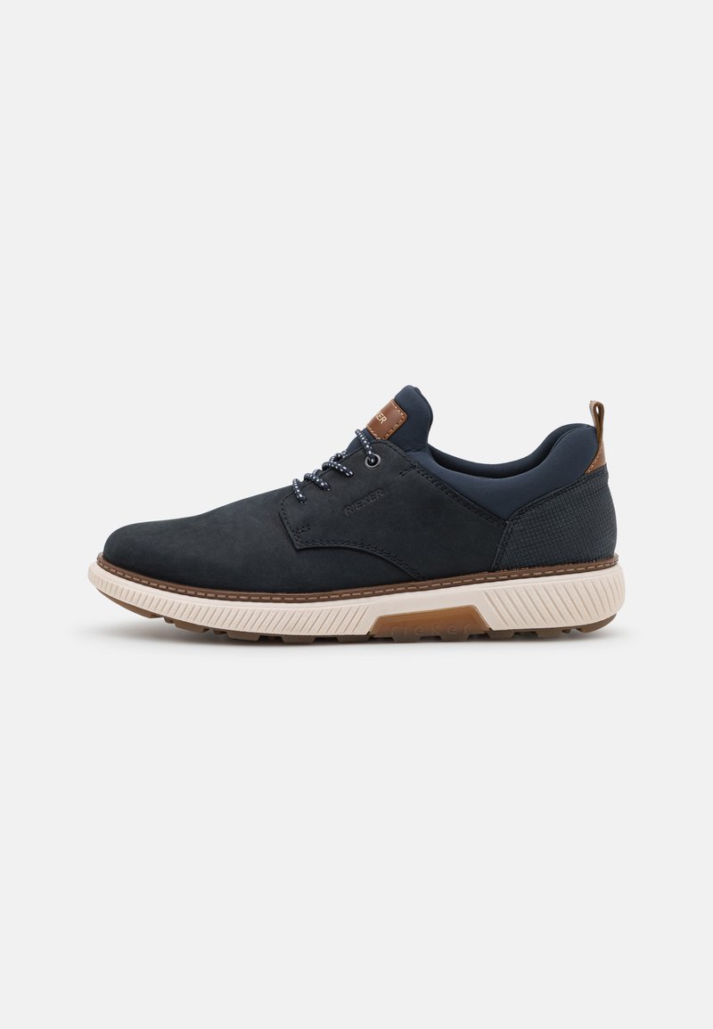 Chaussures en daim bleu marine avec un panneau noir texturé, des accents marron, une semelle intermédiaire blanche et des lacets gris, dotées d'un bout rond et d'une conception robuste.