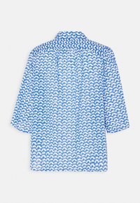 Blusa azul y blanca con un diseño de patrón, cuello tipo polo, mangas tres cuartos y tejido ligero, que presenta un diseño de nubes repetido.