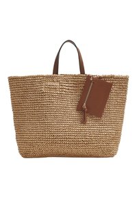 Sac de plage en paille tissée avec des poignées en cuir brun et une pochette zippée en cuir brun attachée sur fond blanc.