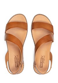 Sandalias de cuero marrón con amplias correas cruzadas, parte trasera abierta, plantillas en tonos naturales y costuras decorativas a lo largo de los bordes.