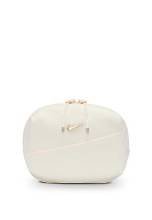 Mała kremowa saszetka Nike z złotymi suwakami i złotym logo Swoosh na przodzie.