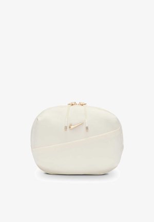 Petite pochette Nike de couleur crème avec des tirettes zippées dorées et un logo Swoosh doré sur le devant.