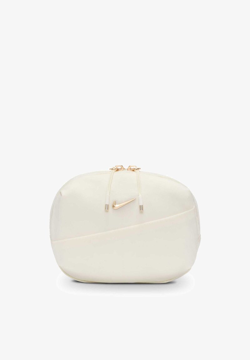 Kleine Nike-Tasche in Cremefarbe mit goldfarbenen Reißverschlusszügen und goldfarbenem Swoosh-Logo auf der Vorderseite.
