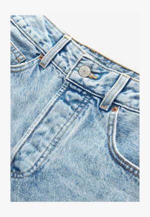 Jeans de mezclilla azul claro con textura desgastada, corte recto y detalles de costura visibles. Cuenta con un botón de metal y pasadores para cinturón.