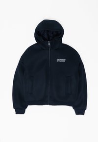 Fekete, cipzáras kapucnis dzseki texturált anyagból, oldalzsebekkel, bordázott mandzsettával és fehér "STUDIO" logóval a mellrészen.