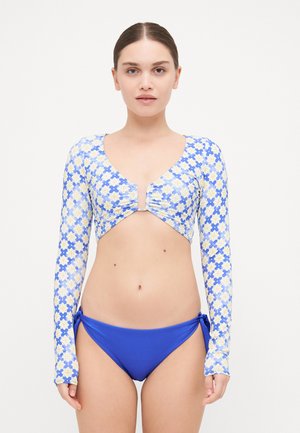 Long-sleeved bikini top with a floral pattern in blue and yellow, featuring a v-neck and ruched detail. Paired with solid blue bikini bottoms.