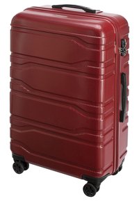Valigia rigida rossa con superficie testurizzata, multiple scanalature, quattro ruote nere e una maniglia laterale per un trasporto facile.
