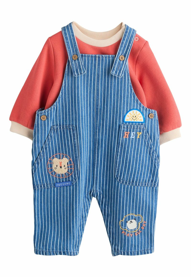 Blå stribede overalls med en orange langærmet skjorte. Har broderede dyremotiver, træknapper og et blødt, struktureret stof.