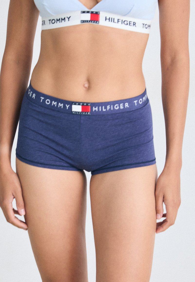 Tmavě modré bavlněné hipster šortky s pasem s logem Tommy Hilfiger a červenými, bílými a modrými akcenty. Hladká textura, přiléhavý střih.