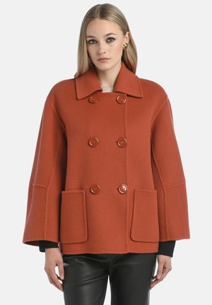 Rust-colored, double-breasted coat with oversized lapels, two front pockets, and wide sleeves. Made of a textured fabric with a soft finish.