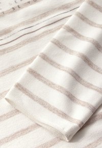 Baumwollstoff mit hellbeigen und weißen Streifen. Weiche Textur mit sauberen Kanten und sichtbaren Nähten. Einfaches, dezentes Design.