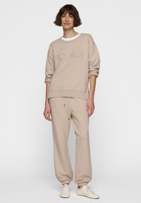 Beige sweatshirt en bijpassende joggingsbroek met een trekkoord. De sweatshirt heeft een reliëf "10 DAYS" logo, een relaxte pasvorm en ribgebreide cuffs.