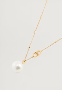 Collana in oro con un grande pendente di perla bianca liscia. Include una chiusura geometrica in oro con un accento del logo.
