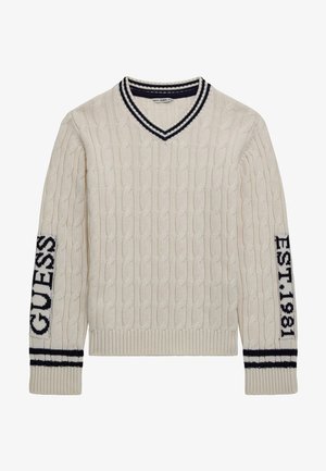 Pull crème en maille torsadée avec col en V orné d'un bord rayé noir, "GUESS" sur la manche gauche, et "EST. 1981" sur la manche droite en texte noir.