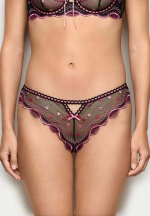 Ropa interior de encaje negro con bordes festoneados rosas y patrones de corazones. Detallado con costuras negras y un pequeño lazo rosa en la parte delantera.