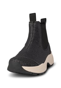 Botas Chelsea negras con un acabado brillante, paneles laterales elásticos y una suela de goma beige. Textura suave y diseño de punta redondeada.