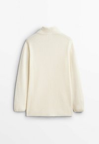 Pull en maille côtelée couleur crème avec des manches longues et un col montant, présenté de dos sur fond blanc.