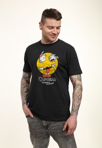 Schwarzes Baumwoll-T-Shirt mit einer Grafik von zwei Cartoon-Tassen auf einem gelben Kreis, mit dem Text "Cuphead: The Delicious Last Course" darunter.