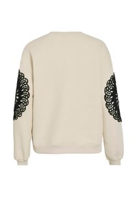 Cream sweatshirt with black lace embroidery on sleeves, ribbed cuffs, and round neck. Soft texture and relaxed fit for comfort.