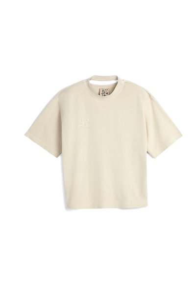 Cremefarvet kortærmet t-shirt i blødt stof, med en subtil broderet design på venstre bryst og rund halsudskæring.